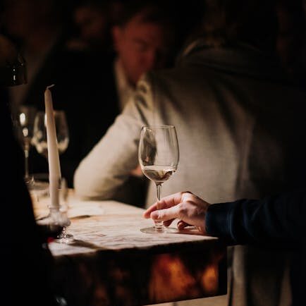 Sophisticated wine tasting in a cozy, dimly lit bar setting featuring elegant glassware and a relaxed ambiance.